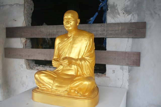 Golden statue with construction behind him