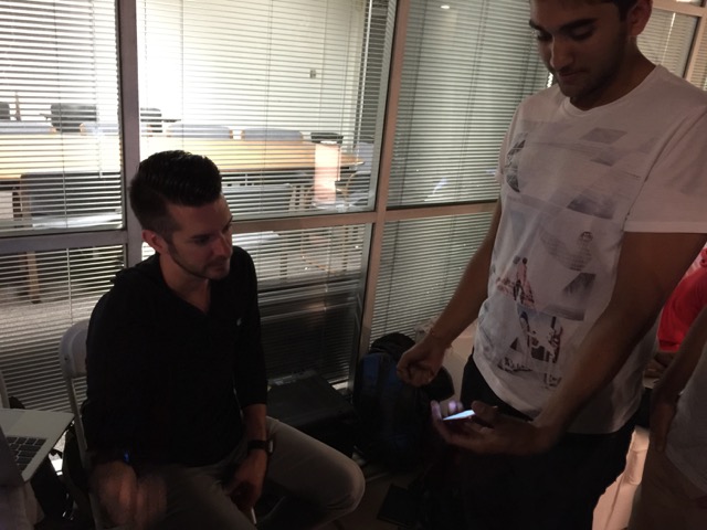 A student demonstrates his app to Bob