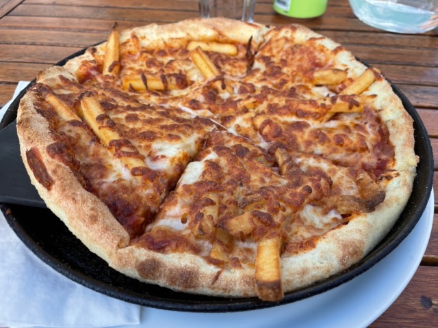 Enjoying delicious french fry pizza at Salka Restaurant in Húsavik
