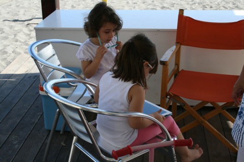 Two kids playing with an iPad 2 on the beach