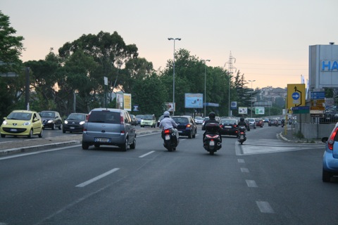 Mopeds zooming in and out of traffic as we approach Roma