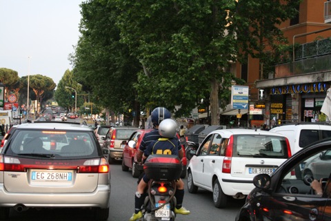 Little kid on the back of a scooter